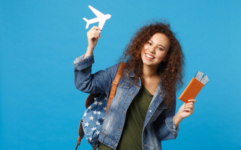 estudiar_en_el_Extranjero_mujer_sostiene_avion_de_papel_y_pasaporte