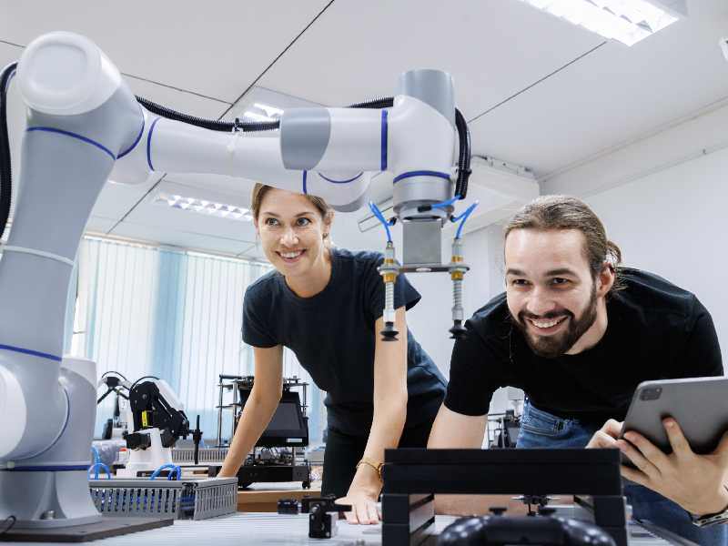 Estudiantes de ingeniería en México estudiando el funcionamiento de una máquina automatizada, preparándose para las demandas del nearshoring en la industria manufacturera