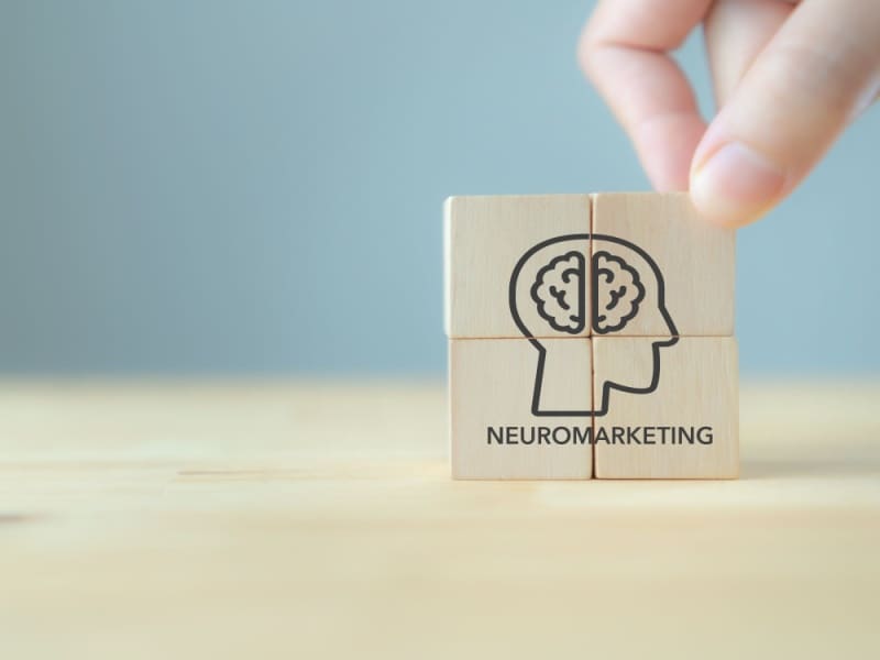 Bloques de madera con icono de cerebro que representan el concepto de neuromarketing y toma de decisiones del consumidor