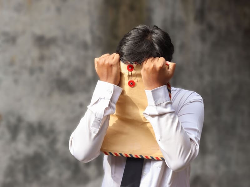 Crisis del egresado y la incertidumbre laboral recién egresado frustrado cubre su rostro con una bolsa