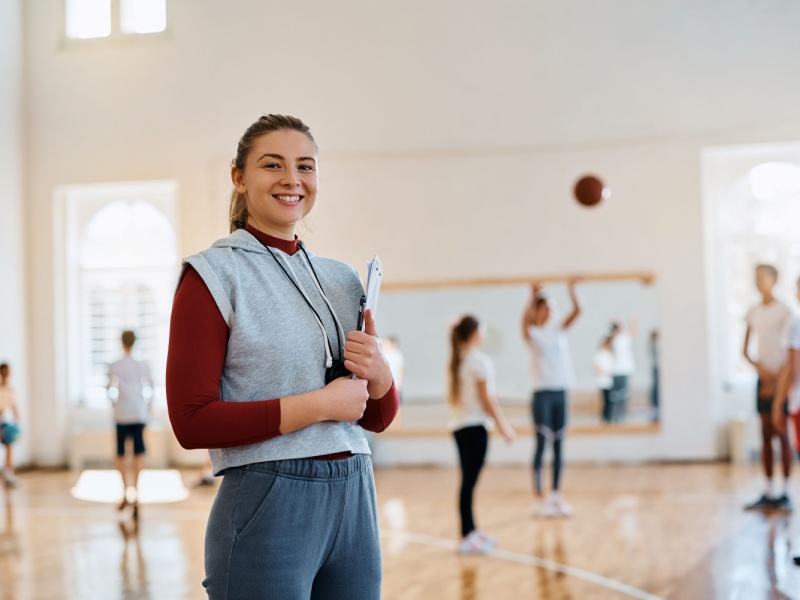 Entrenadora diseñando rutinas de actividad física en gimnasio.
