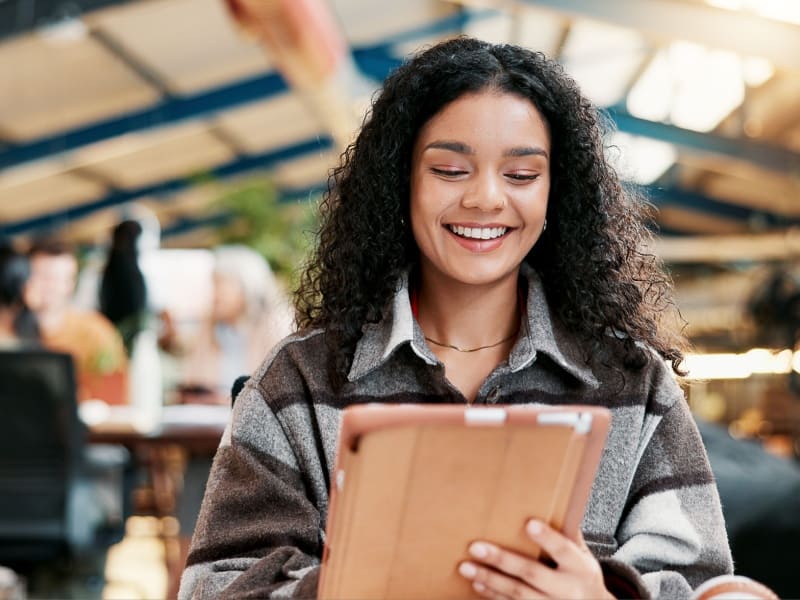 Estudiante universitaria revisando contenidos académicos en una tablet como parte de una licenciatura en línea
