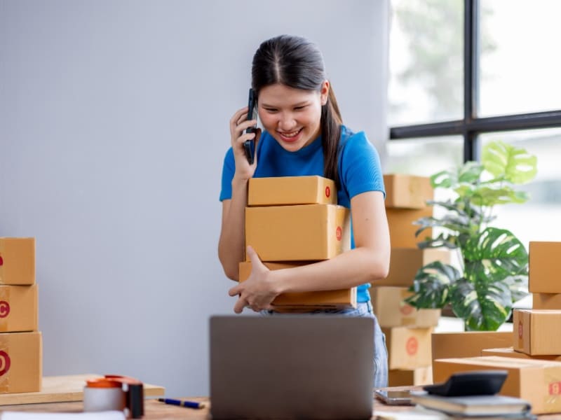 Mujer emprendedora manejando pedidos y llamadas en un negocio de comercio electrónico, mostrando la dinámica del emprendimiento en México.
