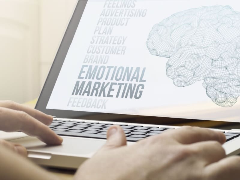 Pantalla de laptop con ilustración de cerebro y palabras relacionadas con marketing emocional y neuromarketing