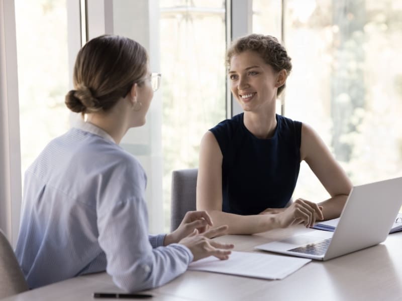 Profesional conversando con colega para recuperar motivación laboral y claridad profesional en un entorno de oficina.