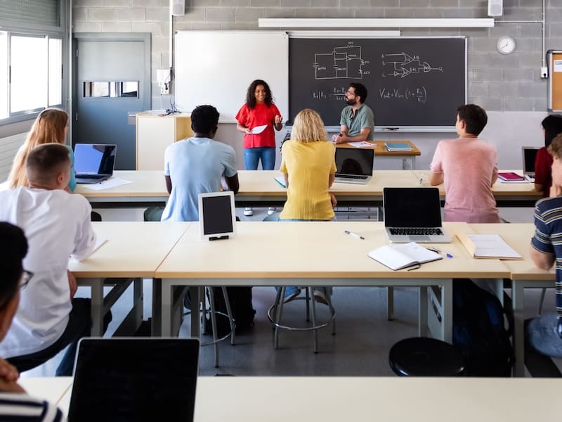 estudiantes de preparatoria exponiendo frente al salón