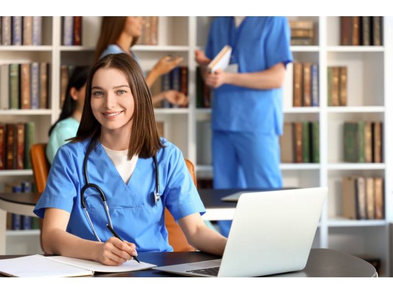  estudiante de medicina usando laptop y libros en biblioteca universitaria