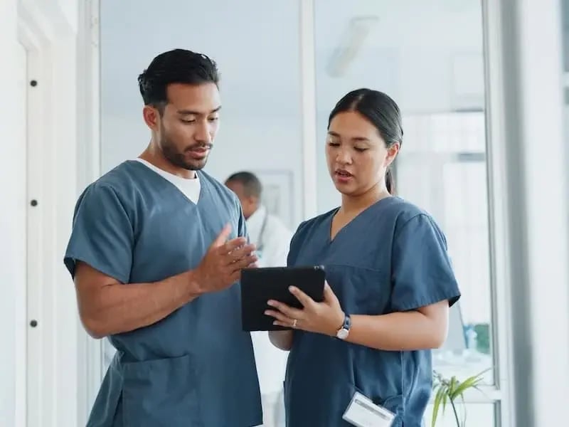 Enfermeros colaborando en plan de atención médica – Trabajo en equipo y comunicación efectiva en la carrera de enfermería.