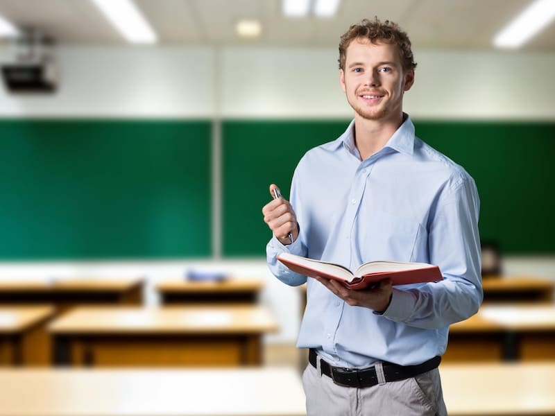 Docente en salón de clases como parte del campo laboral de la carrera de Pedagogía.
