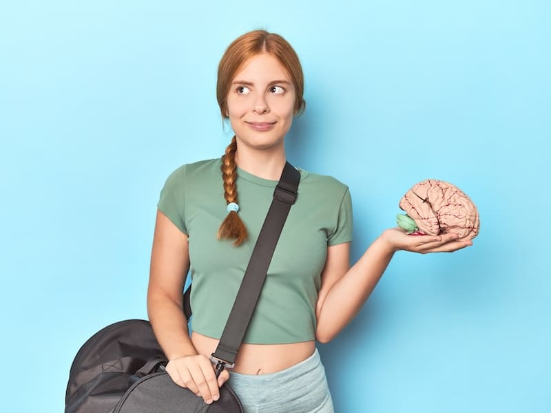 joven m mujer con un cerebro en la mano entendiendo qué son las neurociencias