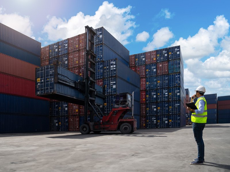 Supervisor logístico inspeccionando contenedores en puerto marítimo – comercio internacional y exportación