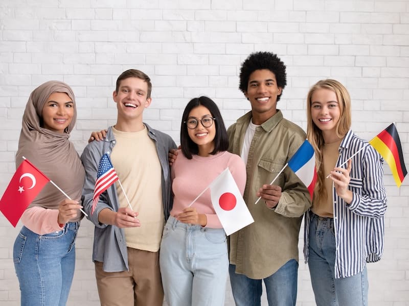 Estudiantes universitarios del extranjero posando con las banderas de sus países