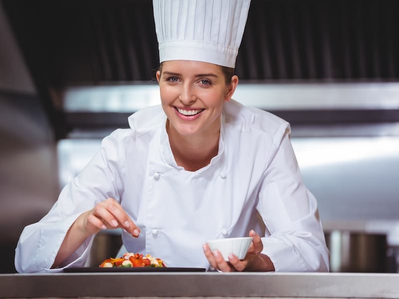 Estudiantes de la licenciatura en gastronomía practicando técnicas culinarias y aprendiendo sobre equipamiento de una cocina profesional en universidad.